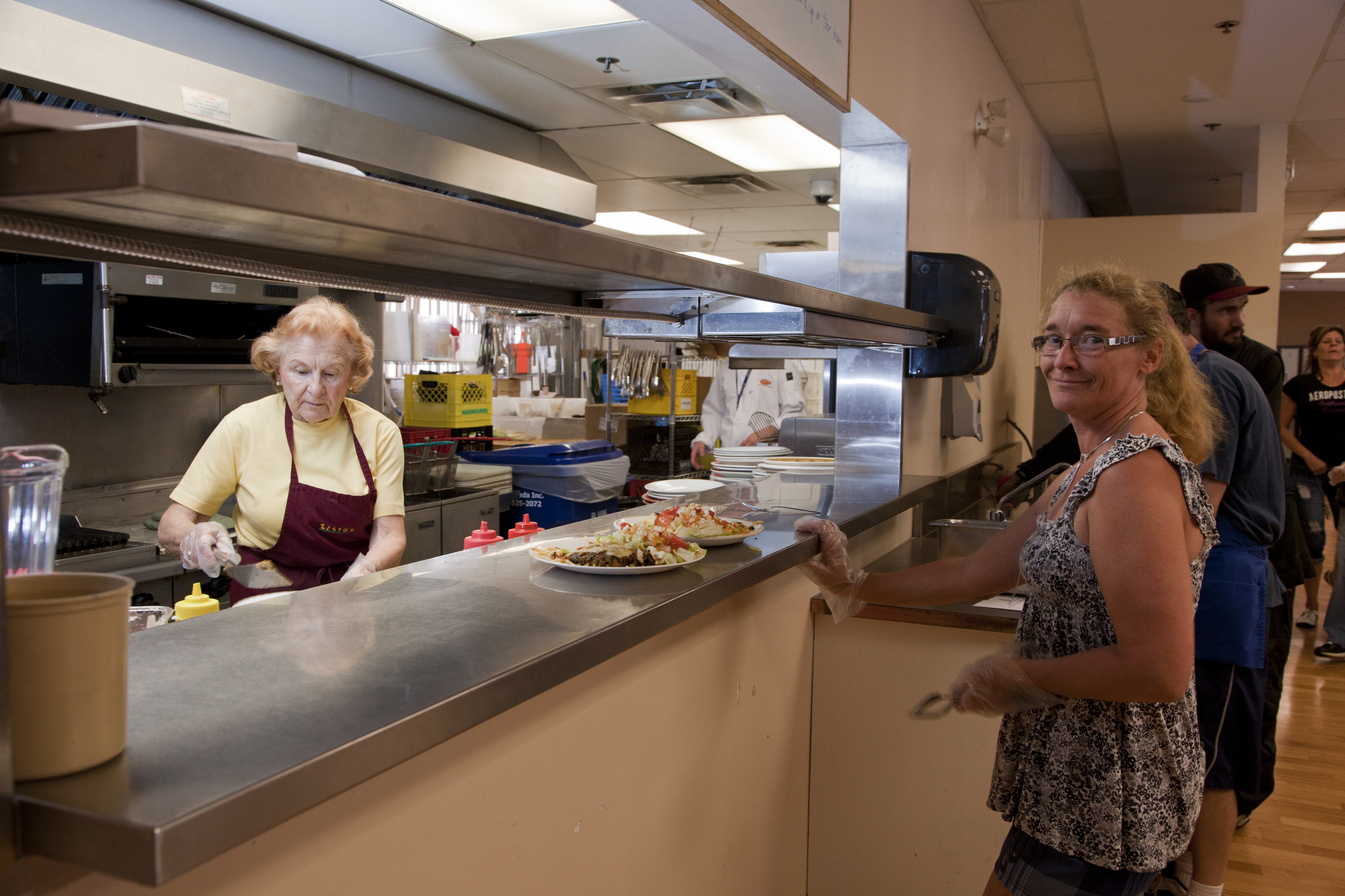 Volunteers serving freshly prepared meals to community members at the Ridge Meadows Ministries community meal program.