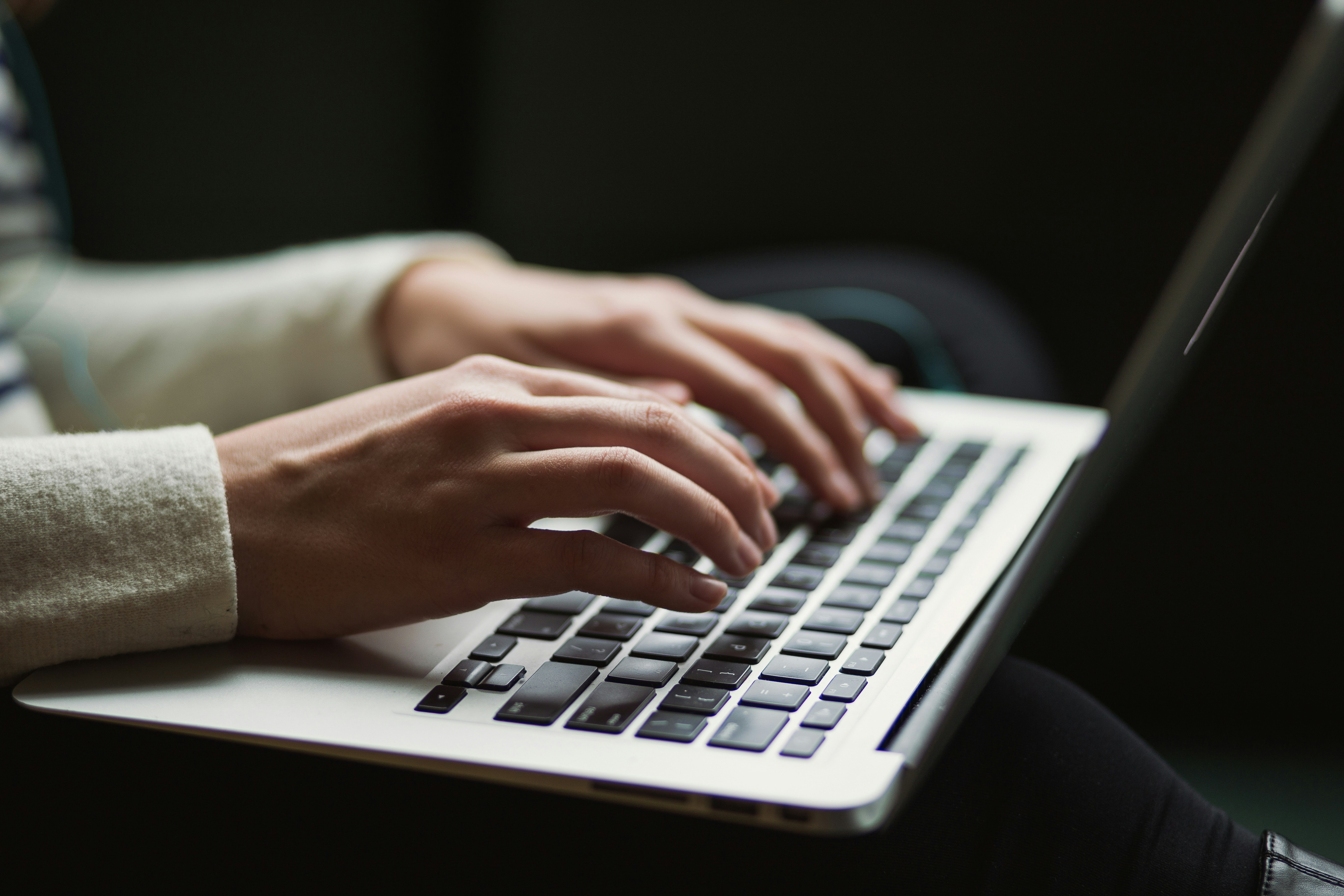 Hands typing on a laptop, representing contacting The Salvation Army to make a donation.